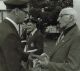 McLaughlin, Victor hands over flag to John Faught at unveiling of cenotaph, 1984